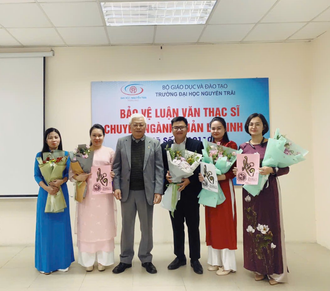Các học viên chụp hình lưu niệm tại buổi lễ bảo vệ luận văn thạc sĩ