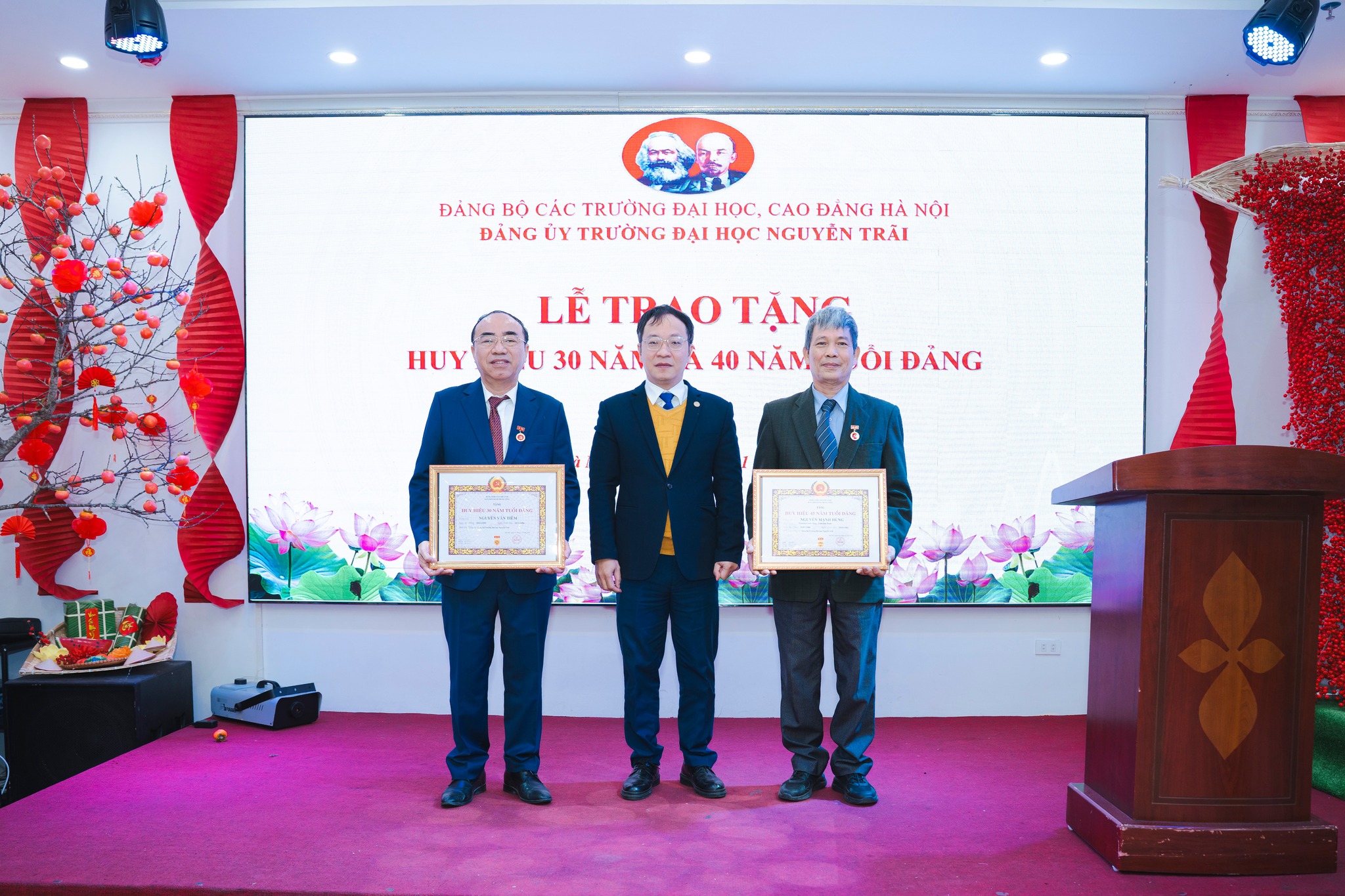 Đ/c Võ Hải Long, Phó Bí thư các trường ĐH, CĐ Hà Nội trao Huy hiệu 30 năm tuổi đảng cho Đ/c Nguyễn Văn Tiêm-Bí thư Đảng ủy Trường, huy hiệu 45 năm tuổi Đảng cho Đ/c Nguyễn Mạnh Hùng - Đảng viên chi bộ 3
